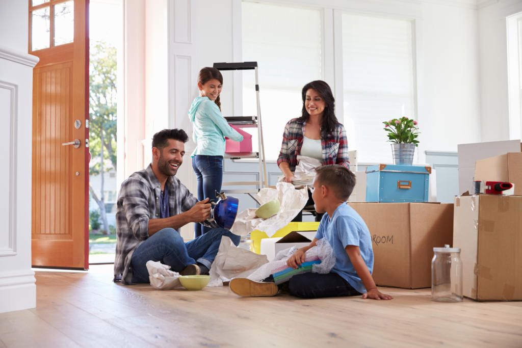 A mother, father, son, and daughter unpacking after moving into a new home